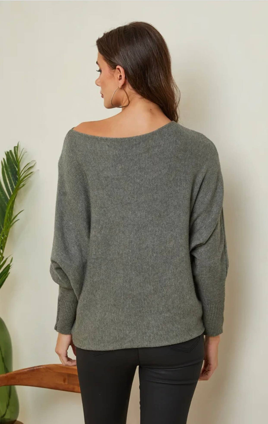 Woman wearing a gray sweater against a plain background