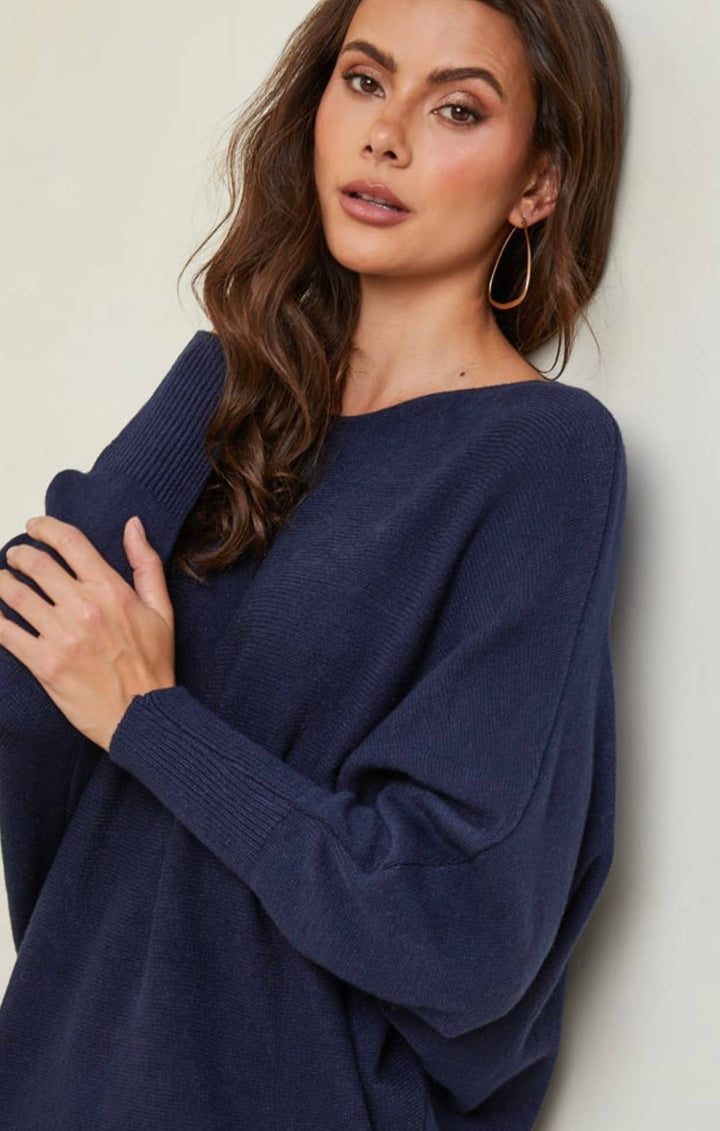 Woman wearing a navy blue sweater against a plain background