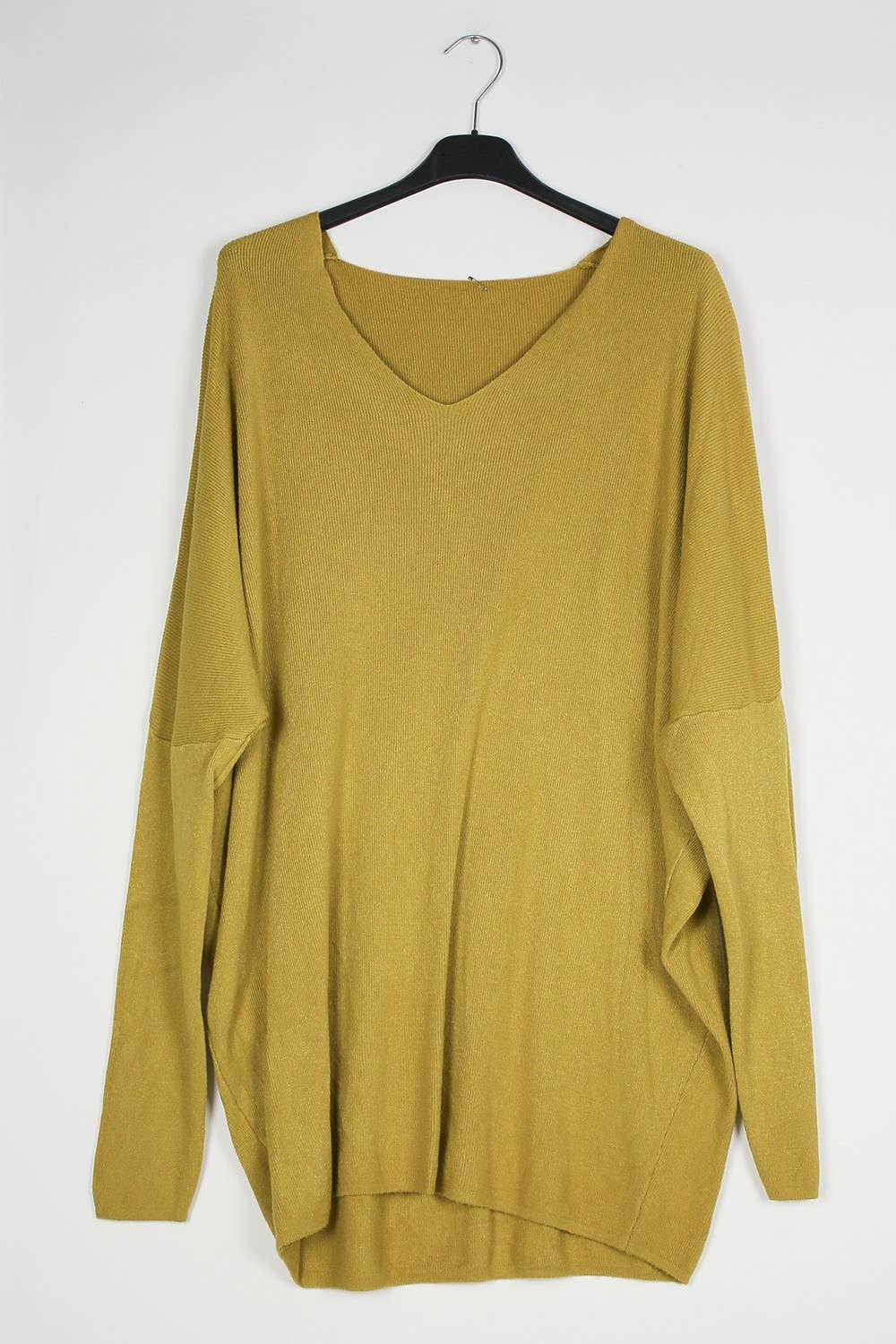 Mustard yellow sweater on a hanger against a white background