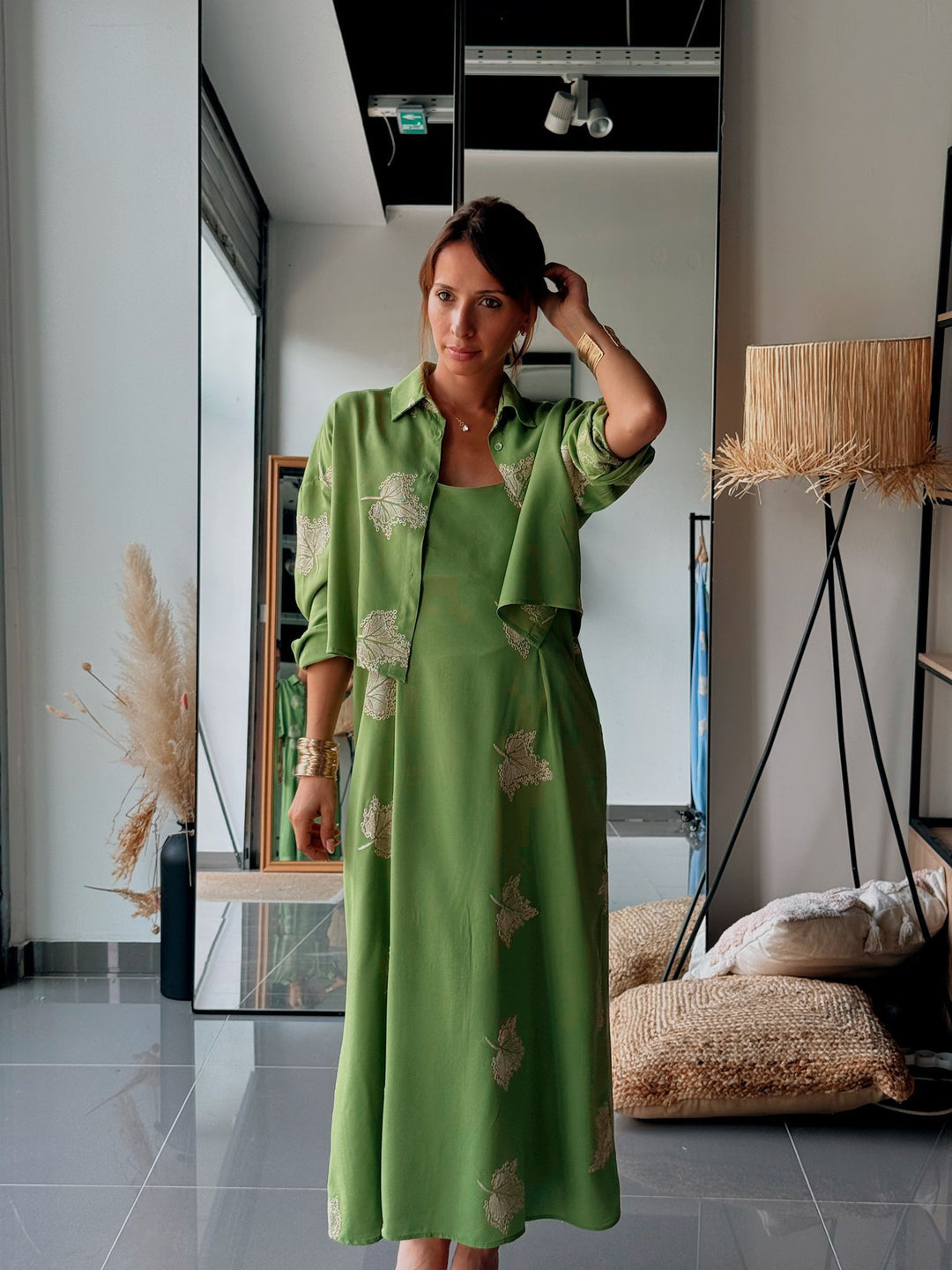 Woman in a green dress standing in a modern interior setting.