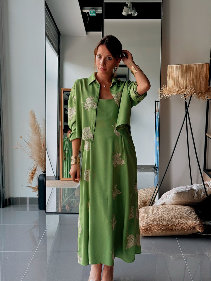 Woman in a green dress standing in a modern interior setting