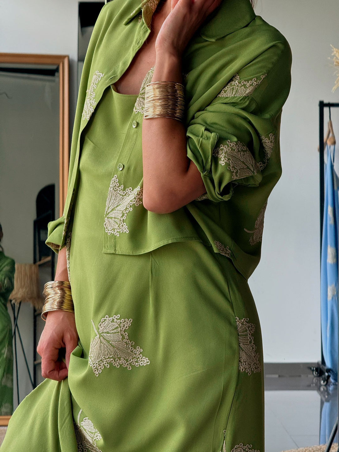 Green outfit with intricate patterns worn by a person indoors.