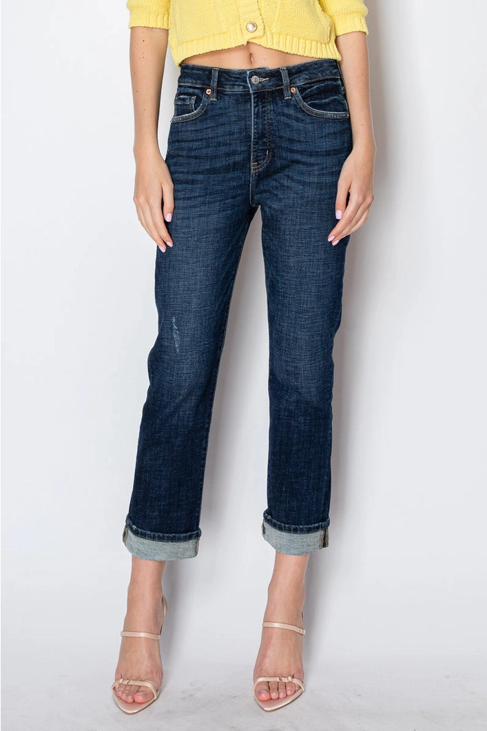 Person wearing dark blue jeans and a yellow top on a white background