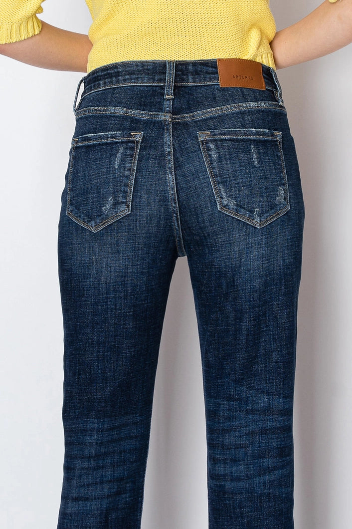 Person wearing blue jeans with a plain background