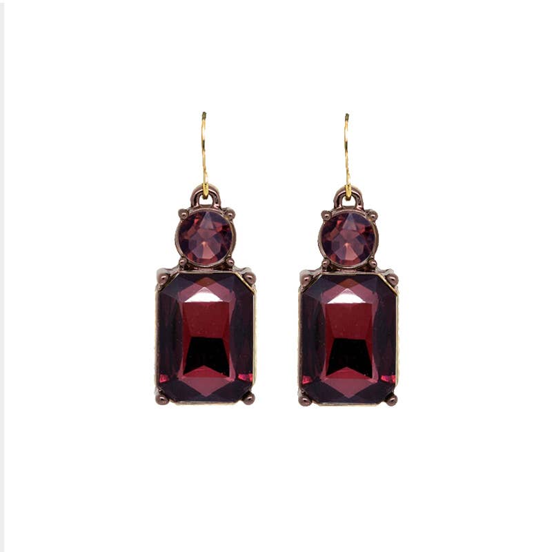 Pair of earrings with red gemstones on a white background