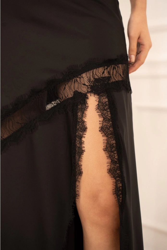 Black lace-trimmed dress with a slit on a white background