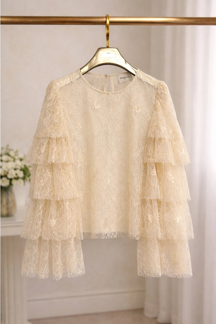 Beige lace dress on a hanger against a neutral background