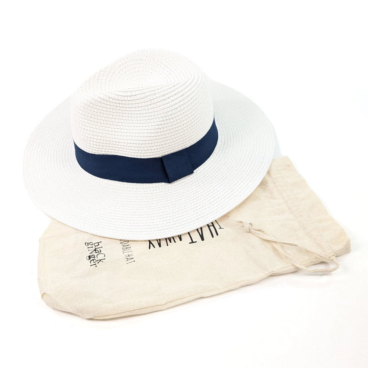 White straw hat with a navy band on a white background
