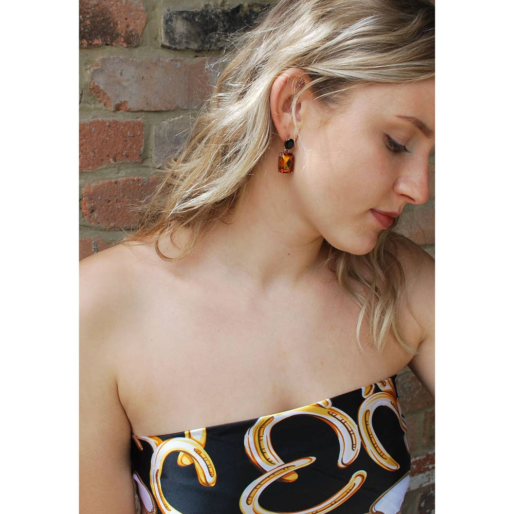 Woman wearing a patterned dress with a brick wall background